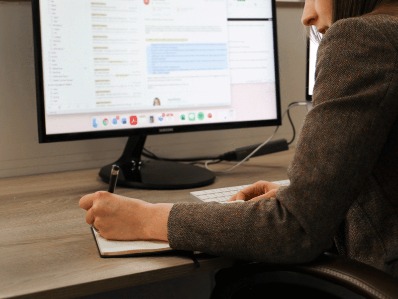 Head of client services sat at a desk writing in a notepad