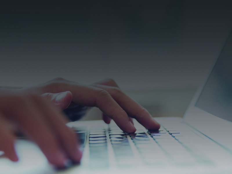 Hands typing on a laptop keyboard